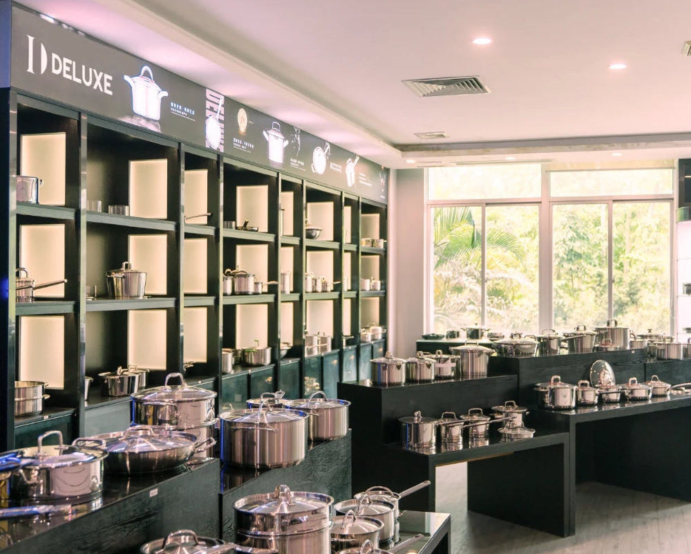 Display of kitchenware in a store with 'Deluxe' branding.