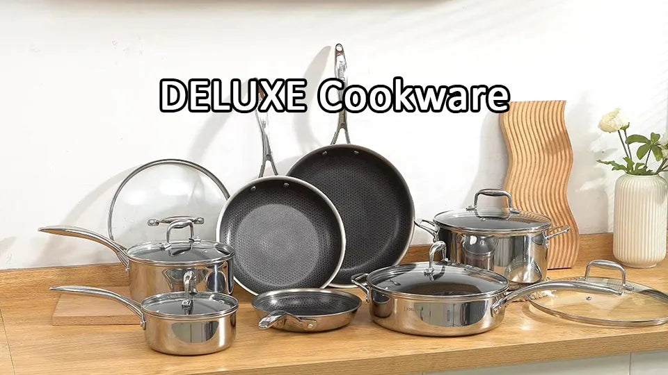 Assorted Deluxe Cookware stainless pots, non-stick pans and glass lids arranged on wooden kitchen counter